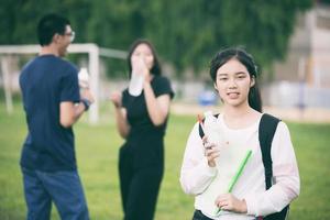 estudante asiática segurando água no campus foto