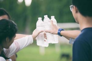 alunos segurando garrafas de água fria no campus foto