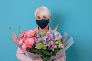 cortada imagem do russo idosos fêmea florista vestindo mascarar e segurando misturado flores lindo ramalhete. generativo ai. foto