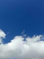 lindas nuvens brancas sobre fundo de céu azul profundo. grandes nuvens fofas e brilhantes cobrem todo o céu azul. foto