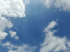 lindas nuvens brancas sobre fundo de céu azul profundo. grandes nuvens fofas e brilhantes cobrem todo o céu azul. foto