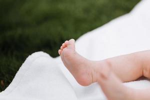 close-up dos pés do bebê recém-nascido em um cobertor branco ao ar livre