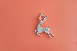 Close lindo cervo prateado de Natal isolado em um fundo cor de pêssego foto