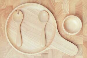 conjunto do garfo, colher e prato madeira em de madeira mesa foto