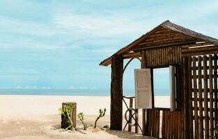 de madeira janela quadro, Armação de a mar dentro ensolarado dia verão, praia cabana em arenoso de praia com janela aberto através oceano mar vista, beira-mar Visão ponto para verão feriado promoção ou produtos apresentação fundo foto