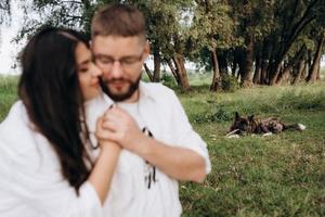 jovem casal apaixonado um cara com barba e uma garota com cabelos escuros em roupas leves foto