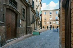 urbino, itália-abril 27, 2019-caminhada através a antigo ruas do urbino durante uma ensolarado dia foto