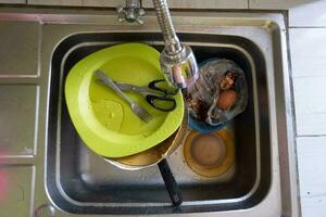 lavar pratos com pilhas do sujo pratos e Comida desperdício foto