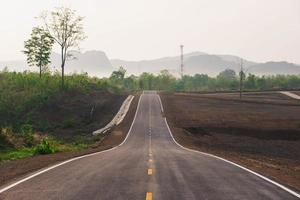 uma longa estrada reta levando a uma montanha foto