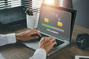 transferir arquivos dados sistema deslocalização conceito, pessoa mão usando computador portátil computador esperando para transferir Arquivo processo com Carregando Barra ícone em virtual tela. foto