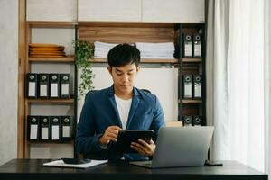 o negócio homem executivo Gerente olhando às computador portátil assistindo conectados webinar Treinamento ou tendo virtual encontro vídeo conferência fazendo mercado pesquisa trabalhando dentro escritório. foto