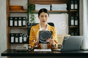 homem de negocios mão trabalhando com Móvel telefone e moderno calcular com vr ícone diagrama às escritório dentro manhã luz foto