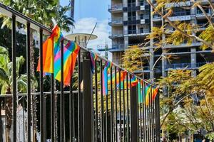 arco Iris bandeiras suspensão em a cerca para decoração antes a orgulho parada foto