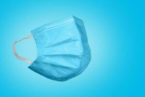 médico mascarar em uma azul fundo. corona vírus proteção conceito. respiratório médico respiratório têxtil protetora mascarar. foto