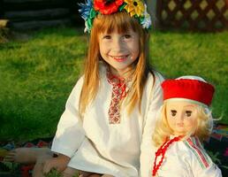 pequeno ucraniano ou bielorrusso menina dentro nacional roupas com a étnico boneca. foto