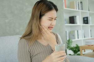 ásia mulher sentir sensível dentes depois de bebendo frio, fêmea Sofra dente, decair problemas, dental Cuidado, dente Extração, decair problema, mau respiração, gengival recessão, oral higiene instrução foto