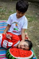 dois feliz Rapazes dentro sociedade parque, feliz ásia irmãos quem estão sorridente alegremente junto. irmãos jogar ao ar livre dentro verão, melhor amigos. criança pequena bebê Garoto jogando com dele feliz irmão dentro a jardim foto