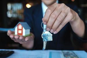 oficial do banco dá a casa das chaves ao cliente depois de fazer um contrato de compra foto