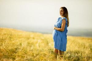 mulher grávida de vestido azul no campo foto