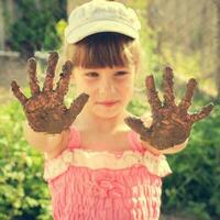 menina mostra dela sujo mãos. tonificado imagem foto