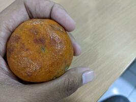 podre laranjas aguarde com mão e sobre a de madeira tabelas. a foto é adequado para usar para fruta fundo e vendedor anúncio.