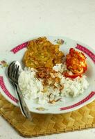 nasi uduk é a estilo cozido no vapor arroz cozinhou dentro coco leite geralmente comido com lado pratos do tempeh, aletria, ovos, e picante batatas, isto Comida é típica Comida a partir de Jacarta . foto