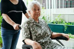 cuidador Socorro ásia idosos mulher incapacidade paciente sentado em cadeira de rodas dentro hospital, médico conceito. foto