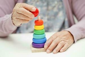 ásia idosos mulher jogando quebra-cabeças jogos para prática cérebro Treinamento para demência prevenção, alzheimer doença. foto