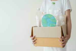 pessoas lançamento uma campanha para reciclar usava esvaziar plástico garrafas. mãos segurando cartão caixa cheio com plástico garrafa pronto para reciclar. conceito do reuso, reduzir, reciclar para Salve  a meio Ambiente foto
