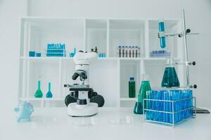 mão do cientista com teste tubo e frasco dentro médico química laboratório azul bandeira fundo foto
