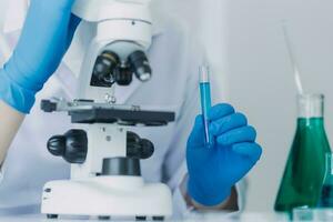 equipe de cientistas de pesquisa bioquímica trabalhando com microscópio para desenvolvimento de vacina contra coronavírus em laboratório de pesquisa farmacêutica, foco seletivo foto