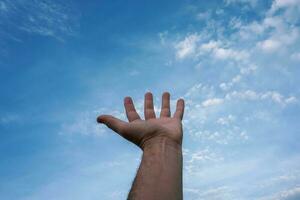 mão para cima gesticulando no céu azul, sentimentos e emoções foto