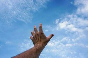 mão para cima gesticulando no céu azul, sentimentos e emoções foto