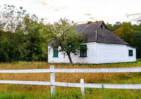 linda e velha casa de fazenda abandonada na zona rural em fundo natural foto