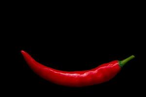 close-up red hot chili spur pepper em um fundo preto foto