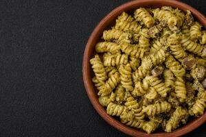 delicioso fusilli massa com verde pesto molho, com sal e especiarias foto