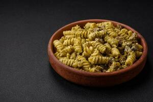 delicioso fusilli massa com verde pesto molho, com sal e especiarias foto