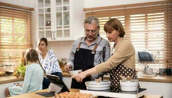 multigeracional família membros explorar Novo e de bom gosto receitas em uma tábua, faço saudável Comida escolhas, cozinhar, e apreciar refeições junto. família encontros Socorro renovar e fortalecer relacionamentos. foto