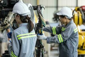 robótico técnicos apertar e afrouxar componentes com Chave de fenda e alicate para executar segurança manutenção. medindo atual, tensão, resistência, capacidade, temperatura com digital braçadeira metro. foto