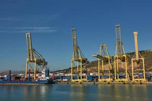 guindaste portuário carrega um contêiner no cais para transporte de importação, exportação e logística comercial em barcelona, espanha