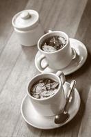 xícaras de chá de coca e açúcar na mesa de madeira foto