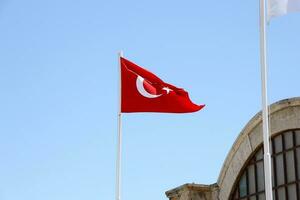 turco bandeira em mastro de bandeira acenando dentro limpar \ limpo azul céu fundo foto