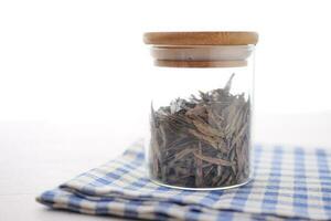seco chá folhas dentro uma recipiente em branco foto