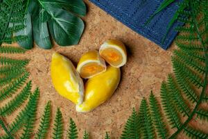 durian pastelaria a fundo é liderar Fora com pano e de madeira tábuas. decorado com artificial folhas foto