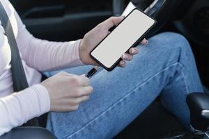 mulher carregando seu telefone no carro foto