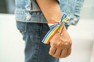 senhora asiática usando pulseiras de bandeira do arco-íris, símbolo do mês do orgulho LGBT, comemora anual em junho social de gays, lésbicas, bissexuais, transgêneros, direitos humanos. foto