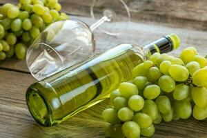 vinho branco com cacho de uva foto