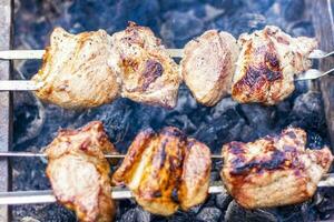 cozinhando uma churrasco em a fogo. tradicional caucasiano Kebab em uma espeto, cozinhando carne em espetos. foto