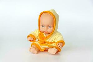 uma brinquedo bebê dentro uma brilhante vestir vestido. boneca em uma branco fundo. foto