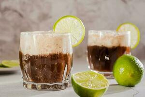 caseiro sujo refrigerante com Cola e Lima dentro óculos em a mesa foto